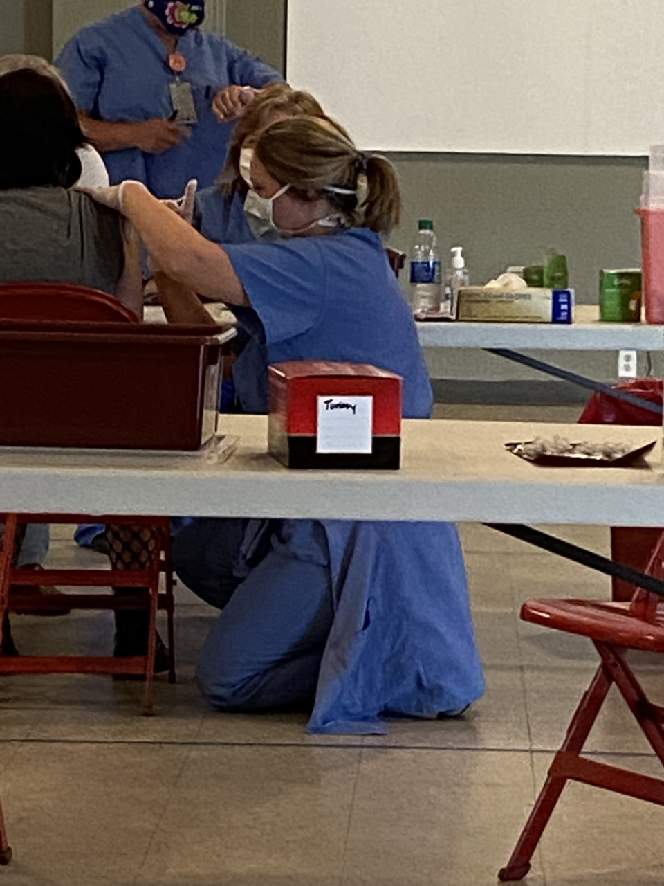 Picture of a vaccination clinic showing a female Nurse giving a vaccination to a female patient.