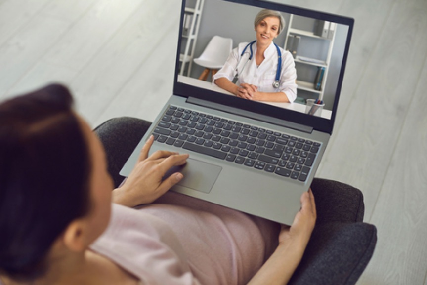 Smiling confident woman doctor therapist consulting man patient online from laptop